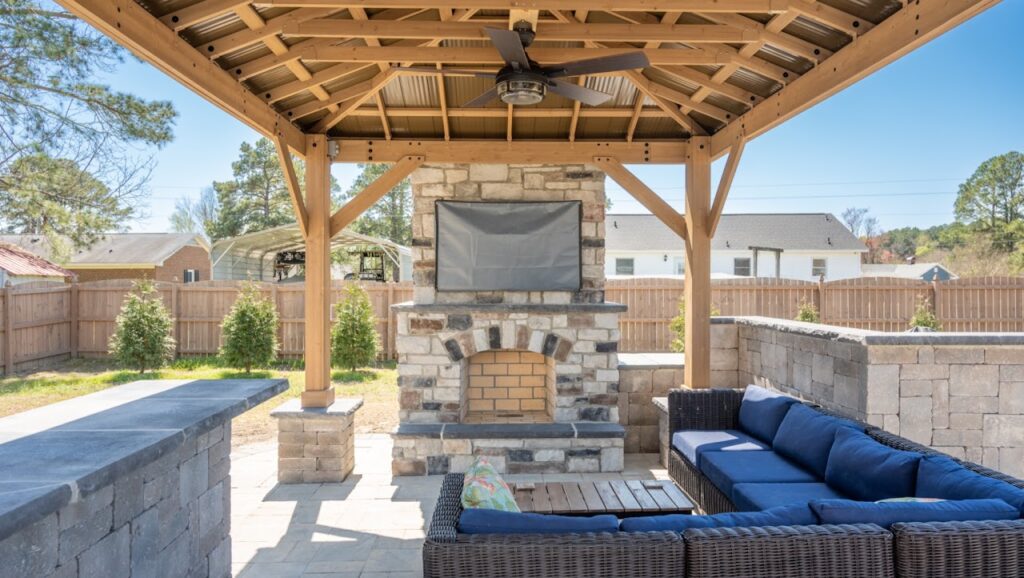 An exterior cultured stone fireplace and retaining wall visable from interior spaces help create a biophilic design.